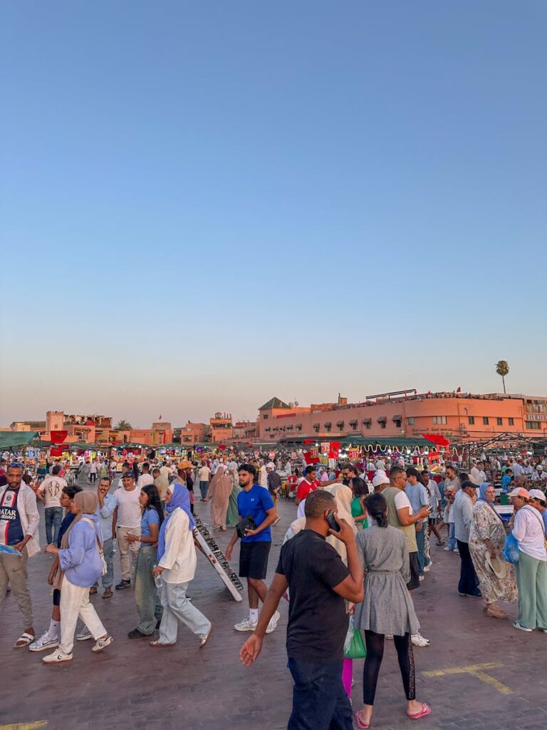 Bustling marketplace atmosphere in Marrakech, filled with people and vibrant colors at sunset. first time in Morocco , Morocco travel
